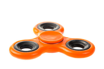 Orange fidget spinner close up, stress relieving toy isolated on white background.