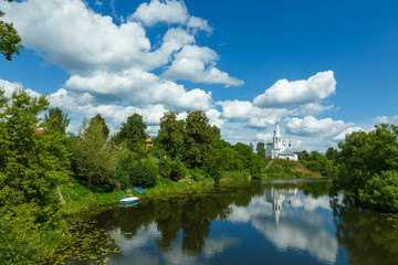 Fototapeta na wymiar Suzdal, Russia. Summer landscape with river, temple on the hill and beautiful clouds in the sky