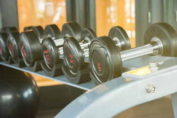 Close up dumbbell set in sport fitness center room for healthy background concept