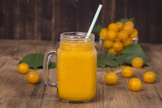 Yellow plum juice in a glass and ripe yellow plum on a vintage wooden table. Bio healthy food and drink. Organic diet.