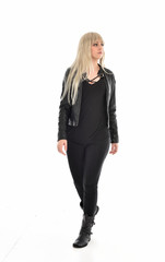 Fototapeta premium full length portrait of blonde girl wearing black leather outfit, standing pose on white background.