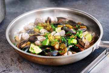 Clams and mussels on hot pan, toned