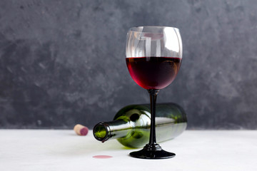 A glass of red wine on black background with bunch of grapes