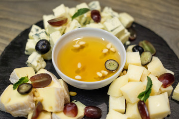 Various cheese plate with honey berries and mint