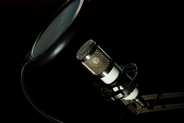 Professional condenser studio microphone on the black background