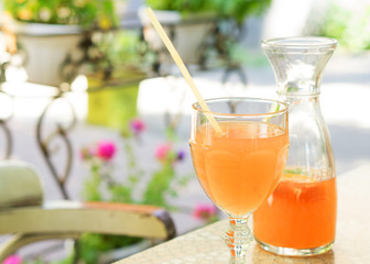 The glass and decanter with a summer grapefruit lemonade, selective focus
