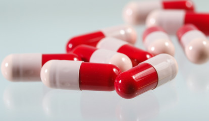 Heap of red and pink antibiotics capsule - obrazy, fototapety, plakaty