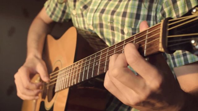 Men play acoustic guitar by hand. Artist musician with instrument close up