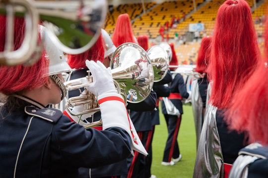 Details from a fanfare music, show and marching band. Playing musicians with wind and percussion instruments in uniforms.