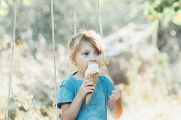 Beautiful girl five years eating ice cream in nature