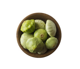 Fresh zucchini in wooden bowl isolated on white background. Top view. Zucchini with copy space for text.