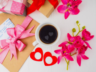 Coffee Cup, close pink gifts, letters and two hearts in the Cup, the concept of romance, love