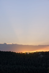 Beautiful sunrise in the morning clear sky with rays and mountain silhouette