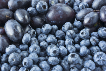 Blue food. Fresh blueberries, grapes and plums background.