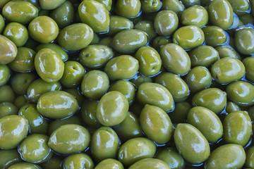 Green delicious marinated olives. Background. Texture. Greece.