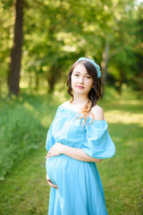 pregnancy, motherhood, people and expectation concept - close up of happy pregnant woman with big belly in park