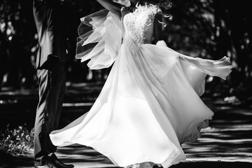 Bride in luxury wedding dress spinning around in front of groom.