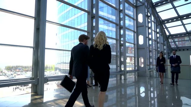 Business people walking in modern glass office building