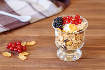 Cup of breakfast healthy muesli with blackberry, red currant and yogurt.