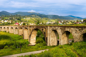 Fototapeta na wymiar Old railway bridge, old viaduct Vorohta, Ukraine. Carpathian Mountains, wild mountain landscape