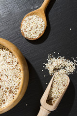 ISOLATED SESAME WITH WOODEN SPOON AND BOWL ON BLACK BACKGROUND