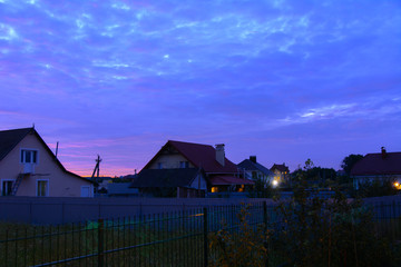 Private houses in the village at sunset. Beautiful night sky. August 2017