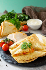 Pressed and toasted double sandwich with chicken, Korean carrots, cheese and tomatoes on a gray stone or slate.