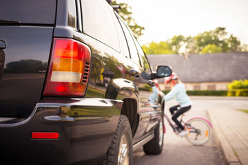 Accident. Girl on the bicycle crosses the road in front of a car