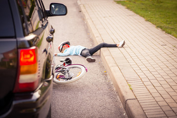 Accident. Girl on the bicycle crosses the road in front of a car