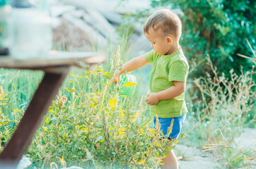 The little boy in the village with a watering can sprinkler