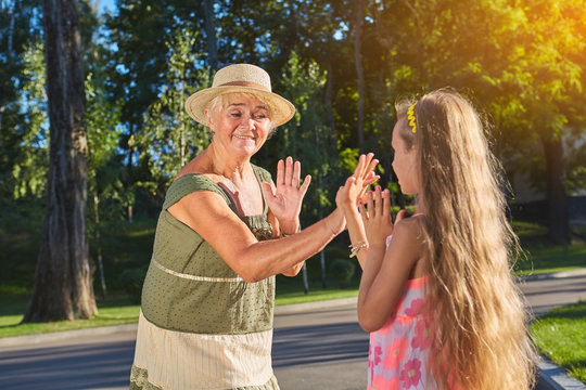 Hand Clapping Game. Grandma With Granddaughter Having Fun.