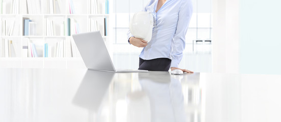 woman holding an helmet work at desk with computer in office, protecting safety concept