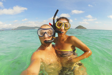 Young Mixed Race Couple Making Selfie Photo Using Waterproof Camera in Clear Ocean after Snorkeling. Phuket, Thailand.