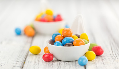 Cocolate coated Peanuts on wooden background (selective focus)
