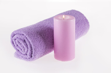Obraz na płótnie Canvas Spa. A towel and a candle of pink color on a white background.