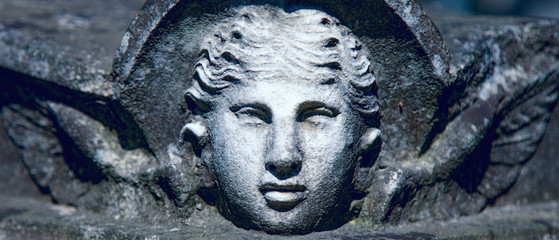 Close up of angel with wings. Vintage stone statue, fragment.