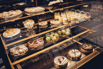 Sweets and cakes in showcase. Italian pastry shop. Cakes with fruits, berries and chokolate