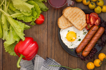 English breakfast - toast, egg, sausages and vegetables salad. Wooden rustic background. Close-up. Top view