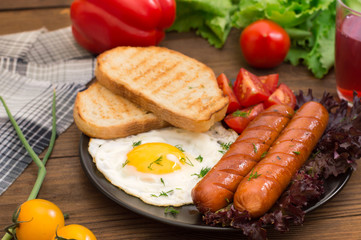 English breakfast - toast, egg, sausages and vegetables salad. Wooden rustic background. Close-up. Top view