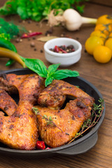 Baked chicken wings in baking pan. Selective focus. Wooden background. Close-up. Top view