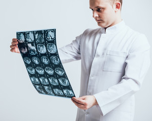 Doctor attentively examines the MRI scan of the patient.