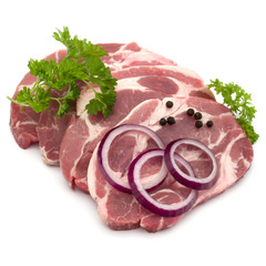 Raw pork neck chop meat with parsley herb leaves, peppercorn spices and onion slices garnish isolated on white background cutout