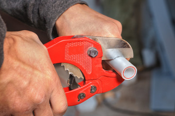 Plumber cuts the ppr pipe using a cutter.