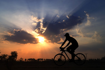 silhouette man ride bicycle in sunset