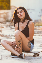 Female skater sitting on skateboard © beornbjorn