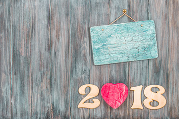 2018 date with heart shape and aged sign board blank on vintage old painted wooden wall planks texture background. Retro style filtered photo