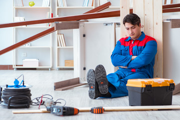 Young carpenter taking break from working with wooden planks