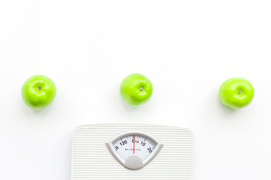 Bathroom scale and apples on white background top view copyspace