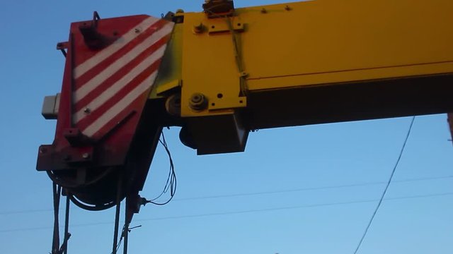 yellow automobile crane with rise n telescopic boom outdoors over blue sky