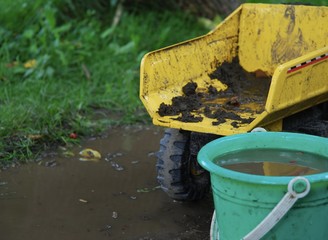 Playing in the mud with a dump truck and bucket
